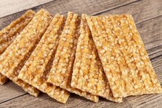 crackers are stacked on top of each other on a wooden table, ready to be eaten