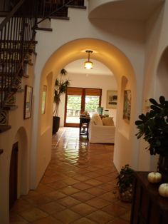 an archway leading to a living room and dining room with stairs in the hallway between two rooms