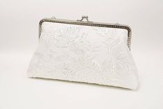 "For brides-to-be, this is a delightful accessory to complement any bridal occasion look. Carry as a hand clutch or attach the handle chain. Top clasp closure. Soft and romantic! This white delicate made from white embriodered lace overlaid on white, a little dazzling with clear sequins, lining in beautiful blue silk or can be custom color (choose from rose chart), secured closure with brass purse frame and comes with handle chians. Versatile to compliment most styles and big enough to carry all Elegant Handheld Clutch For Gift, Elegant Wedding Pouch Evening Bag, Elegant Pouch Evening Bag For Wedding, Elegant Clutch For Wedding, Elegant Wedding Evening Pouch Bag, Silver Pouch Evening Bag For Wedding, Chic Rectangular Clutch For Wedding, White Rectangular Evening Bag For Wedding, Elegant White Evening Bag For Wedding