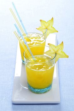 two glasses filled with orange juice on a white plate