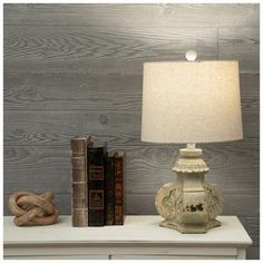 a lamp sitting on top of a white table next to books and a book case