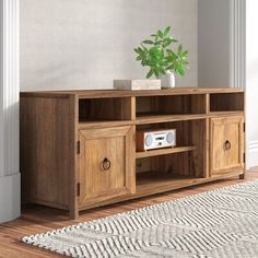 a wooden entertainment center sitting on top of a hard wood floor next to a white rug