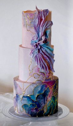 a three tiered cake with purple and blue icing