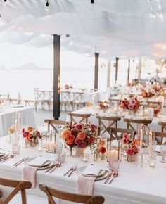 the tables are set with candles, flowers and place settings for an elegant wedding reception