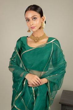 Green saree in organza base with hand embroidered floral buttis. Paired with chanderi blouse. Comes with satin petticoat.
Component: 3
Pattern: Embroidered
Type Of Work: Floral Motifs
Neckline: Round
Sleeve Type: Half Sleeves
Fabric: Saree: Organza; Blouse; Chanderi; Petticoat: Satin
Color: Green
Other Details: 
Sequins work
Back scoop neck blouse
Note: The gold jewellery set worn by the model is for styling purpose only
Occasion: Wedding - Aza Fashions Transitional Party Organza Pre-draped Saree, Gold Organza Pre-draped Saree For Navratri, Navratri Celebration Pre-draped Saree With Zari Work, Traditional Party Pre-draped Saree In Chanderi, Eid Celebration Pre-draped Saree, Party Wear Cotton Silk Sets With Sheer Dupatta, Festive Chanderi Pre-draped Saree For Celebration, Traditional Georgette Pre-draped Saree For Celebration, Bollywood Style Art Silk Pre-draped Saree With Sheer Dupatta