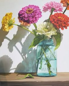 a painting of colorful flowers in a blue mason jar on a wooden table with shadow