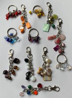 a bunch of key chains that are all different colors and shapes with charms attached to them