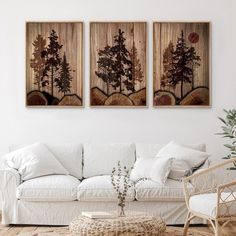 two paintings hanging on the wall above a white couch in a room with wood flooring