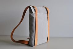 Modern Everyday Backpack With Waxed Finish, Modern Standard Backpack With Waxed Finish, Modern Waxed Finish Standard Backpack, Everyday Practical Leather Backpack, Modern Canvas Backpack For On-the-go, Rectangular Leather Backpack With Leather Trim, Rectangular Backpack With Leather Handles For Commuting, Rectangular Commuting Backpack With Leather Handles, Modern Canvas Standard Backpack