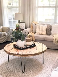 a living room filled with furniture and a coffee table in front of a window on top of a rug