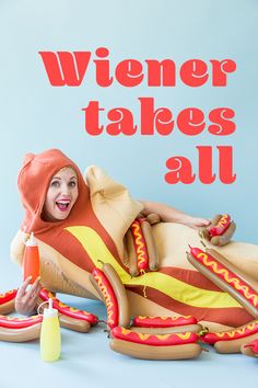 a woman laying on top of a giant hot dog inflatable chair with the words wiener takes all