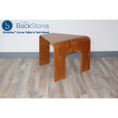 a wooden stool sitting on top of a hard wood floor next to a wall with the back store logo