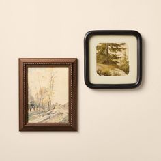 two framed pictures hang on the wall next to each other, one with a painting