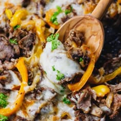 a skillet filled with cheese and meat covered in melted cheese, bell peppers and parsley