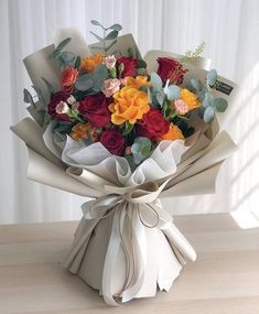 a bouquet of flowers is wrapped in white paper