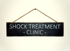 a sign that says shock treatment clinic hanging on a wall