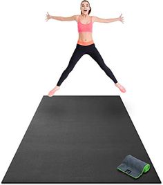 a woman jumping on top of a yoga mat