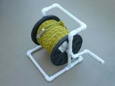 there is a spool of yellow and black rope in the holder on the floor