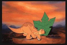 an animated image of a dinosaur laying on its back next to a leaf in the desert