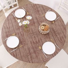 an overhead view of a dining table with white plates and silverware on the top