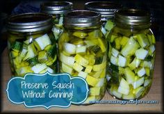 four jars filled with pickles sitting on top of a table