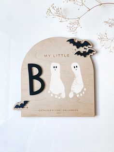 a wooden sign that says my little boo and two ghostes on it with bats flying around