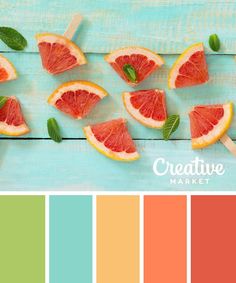 grapefruits and mint leaves are arranged on a blue wooden table with color swatches