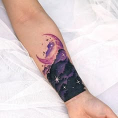 a woman's arm with a purple and black tattoo on it, the moon is in the sky