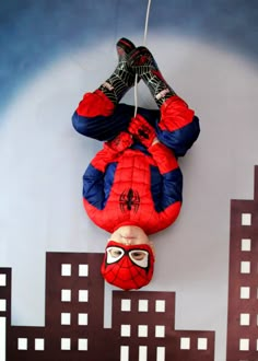 a spider man hanging from the side of a wall