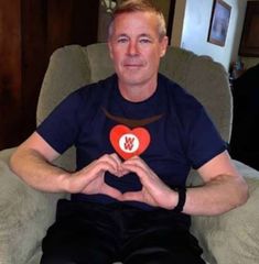 a man sitting in a chair holding a heart