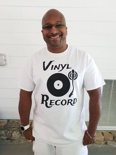 a man standing in front of a white wall wearing a vinyl record t - shirt