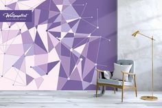 a chair sitting in front of a wall with purple geometric designs on it and a lamp next to it