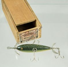 a fishing lure in a wooden box on a white surface