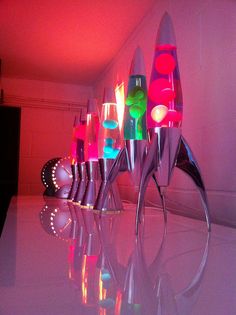 there are many different colored lights in the vases on the table and one is upside down