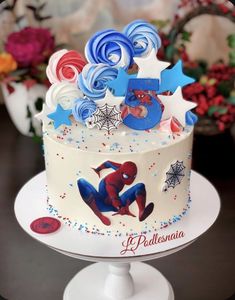 a spiderman themed birthday cake with stars and swirls