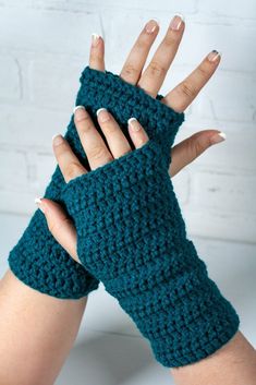 a woman's hand with two crocheted fingerless gloves