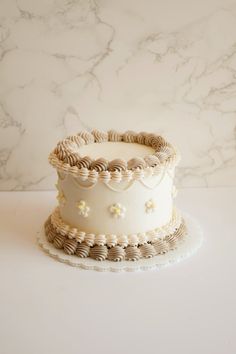 a small white cake sitting on top of a table next to a marble countertop