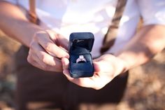 a man is holding an engagement ring in his hand and it's inside the box