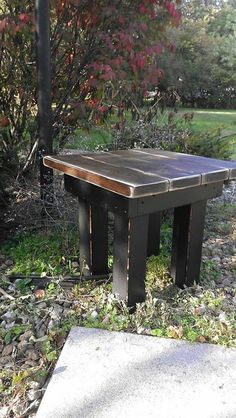 a wooden bench sitting on top of a grass covered field