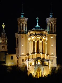 an old building lit up at night with lights on