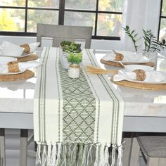 the table is set with white and green place mats, napkins, and plates