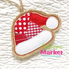 a red and white christmas ornament hanging from a string on top of a bed