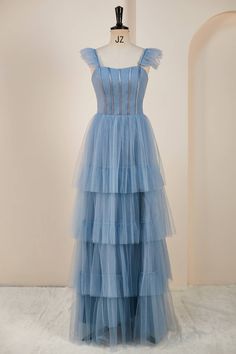 Be entranced by the ethereal elegance of this misty blue tiered ruffles long dress! It's crafted with delicate tulle and boasts an A-line silhouette with mesmerizing flare straps and a lace-up back. Fall in love with its full length ruffled skirt that will have you twirling until the sun rises! Item #NP1002 Material: Tulle Silhouette: A-line Embellishment: Tiered ruffles full length skirt Sleeves: flare straps Back: Lace-up Length: Full length Fully lined: Yes Built-in bra: Yes True to size. Mad Blue Tiered Tulle Dress, Blue Tiered Tulle Skirt Dresses, Layered Prom Dress, Short White Dress Wedding, Knee Length Wedding Dress, Mini Wedding Dresses, Spaghetti Strap Prom Dress, Evening Dress Fashion, Long Bridesmaid Dress