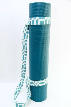 a blue yoga mat with a white ribbon on it and a roll of tape in the middle