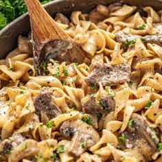 a skillet filled with pasta, mushrooms and parsley