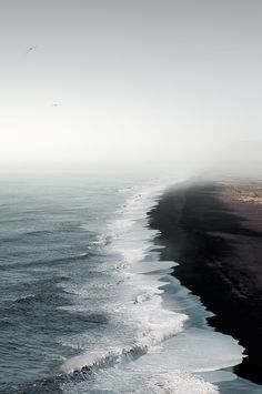 the beach is lined with black sand and water