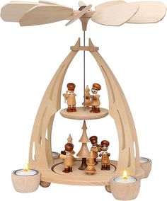 a group of wooden figurines sitting on top of a table next to candles