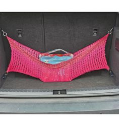 the back end of a car with a pink netted bag in it's trunk