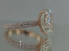 a close up view of a diamond ring on a reflective surface