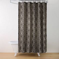 a black and white shower curtain with an intricate design on the bottom, in front of a bathtub